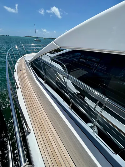  Yacht Photos Pics 2023 Azimut Fly 60 yacht with sleek design and wooden deck, cruising on a sunny day.