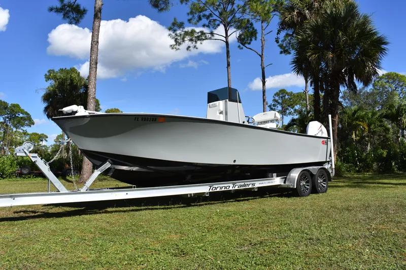  Yacht Photos Pics 2025 Latitude Tournament Boats 25 on trailer, parked on grass with trees in background.