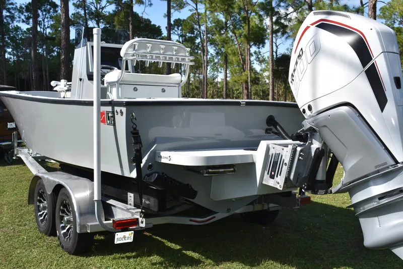  Yacht Photos Pics 2025 Latitude Tournament Boats 25 on trailer with powerful outboard motor in a wooded area.