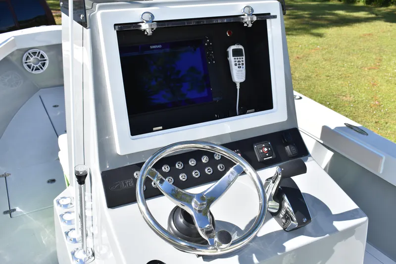  Yacht Photos Pics 2025 Latitude Tournament Boats 25 helm with steering wheel, control panel, and navigation display.