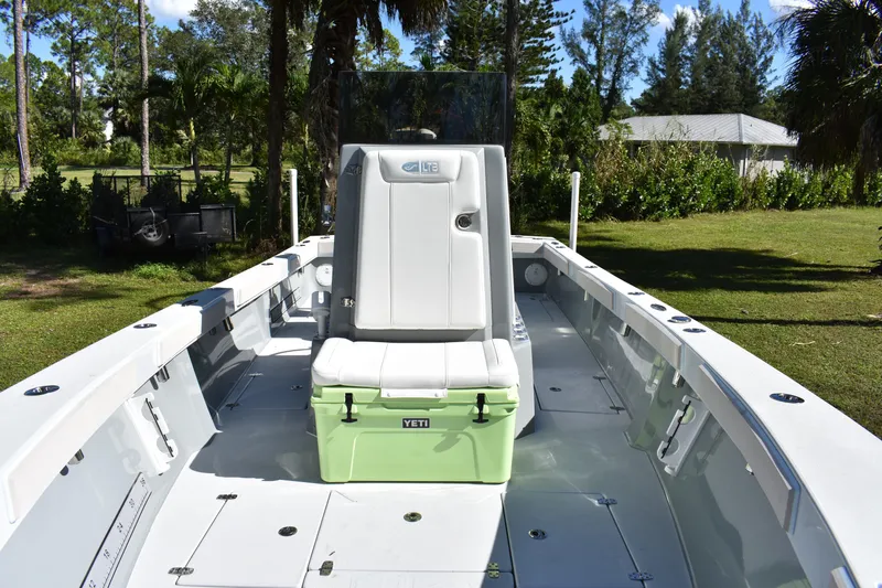  Yacht Photos Pics 2025 Latitude Tournament Boats 25 interior with seating and Yeti cooler, surrounded by lush greenery.