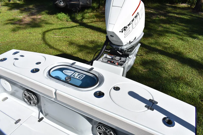  Yacht Photos Pics 2025 Latitude Tournament Boats 25 with powerful outboard motor and livewell, set on grassy background.