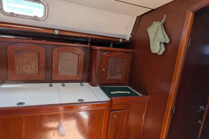 Must Love Dogs Yacht Photos Pics Interior of a 1996 Beneteau 50 yacht with wooden cabinetry and a small window.