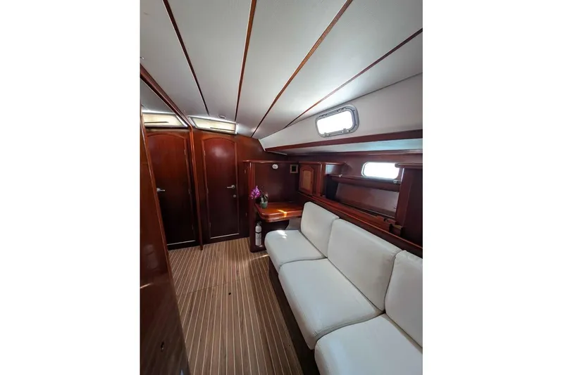 Must Love Dogs Yacht Photos Pics Interior of 1996 Beneteau 50 yacht with white sofa and wooden accents.