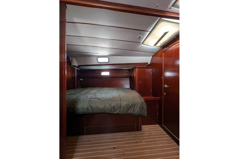 Must Love Dogs Yacht Photos Pics Cozy cabin interior of 1996 Beneteau 50 yacht with wooden finish and bed.