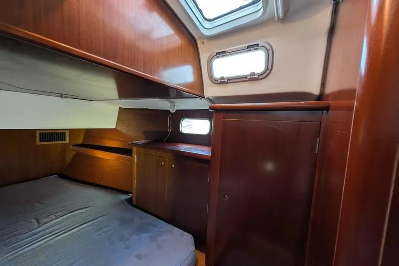 Must Love Dogs Yacht Photos Pics Cozy cabin interior of 1996 Beneteau 50 sailboat with wooden furnishings and porthole.