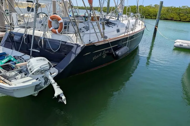 Must Love Dogs Yacht Photos Pics 1996 Beneteau 50 sailboat docked, featuring Suzuki outboard motor and lifebuoy.