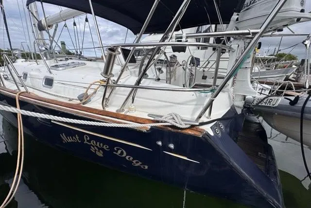 Must Love Dogs Yacht Photos Pics Beneteau 50 sailboat, 1996 model, docked with "Must Love Dogs" name on hull.