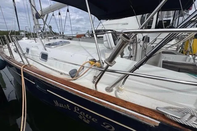 Must Love Dogs Yacht Photos Pics 1996 Beneteau 50 sailboat docked, featuring sleek white deck and polished wood accents.