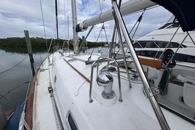 Must Love Dogs Yacht Photos Pics 1996 Beneteau 50 sailboat deck with stainless steel fittings and calm marina backdrop.