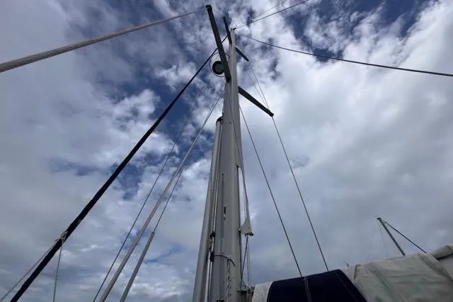 Must Love Dogs Yacht Photos Pics Mast of 1996 Beneteau 50 sailboat against a cloudy sky.