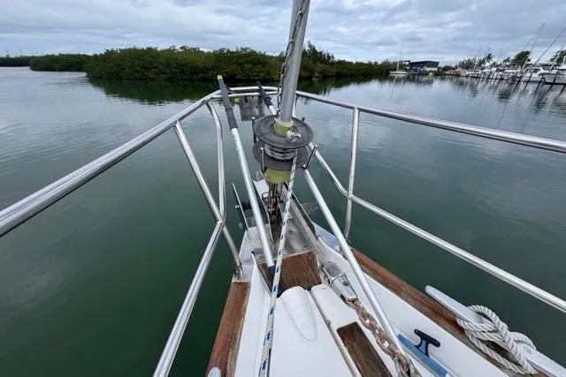Must Love Dogs Yacht Photos Pics Bow of 1996 Beneteau 50 sailboat with railing, anchored in calm waters.