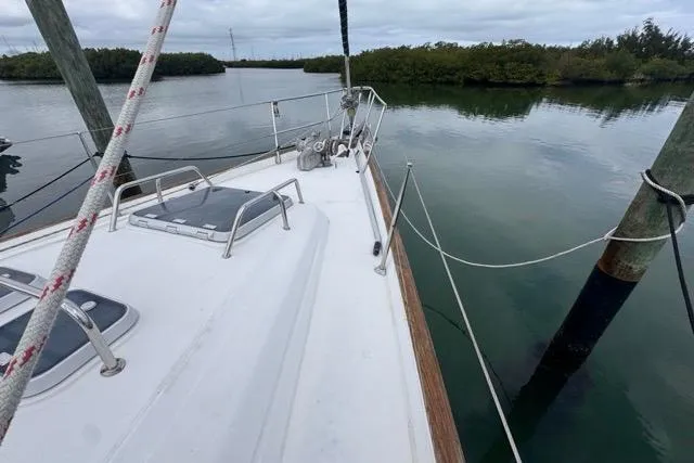 Must Love Dogs Yacht Photos Pics Sailing yacht Beneteau 50 (1996) docked in calm waters, featuring a spacious deck.