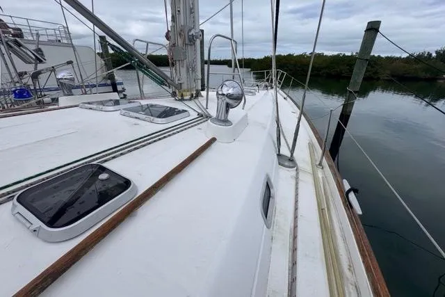 Must Love Dogs Yacht Photos Pics 1996 Beneteau 50 sailboat deck with hatches, docked by calm water.