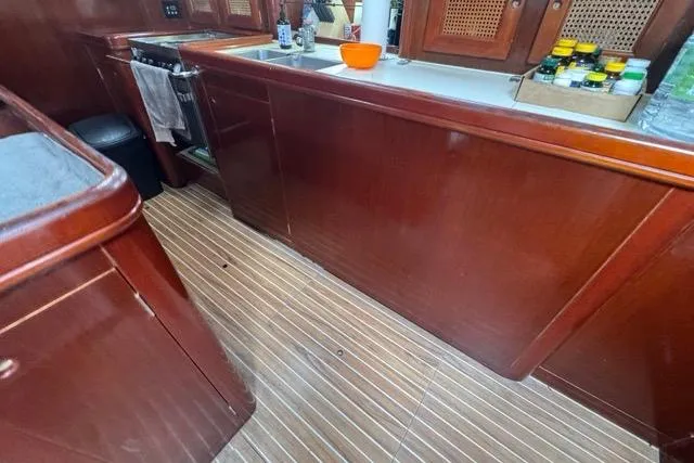 Must Love Dogs Yacht Photos Pics Interior of 1996 Beneteau 50 yacht with wooden cabinetry and striped flooring.