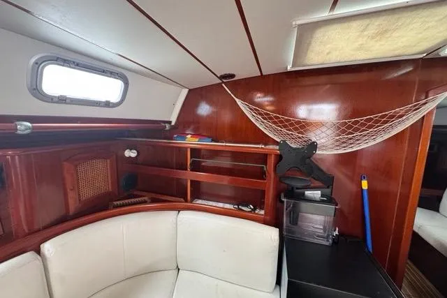 Must Love Dogs Yacht Photos Pics Interior of 1996 Beneteau 50 yacht with wooden finish and white seating.