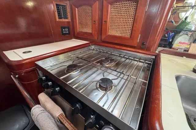 Must Love Dogs Yacht Photos Pics Galley kitchen in 1996 Beneteau 50 sailboat with stove and wooden cabinetry.