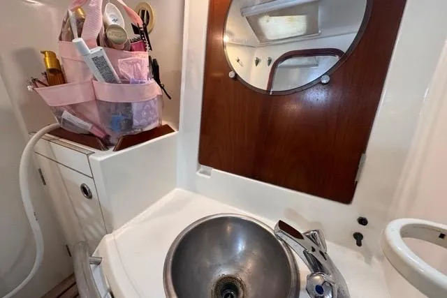 Must Love Dogs Yacht Photos Pics Bathroom sink area in a 1996 Beneteau 50 yacht with toiletries and mirror.