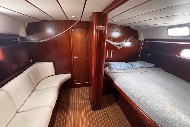 Must Love Dogs Yacht Photos Pics Luxurious 1996 Beneteau 50 yacht cabin with wooden interior, bed, and seating area.
