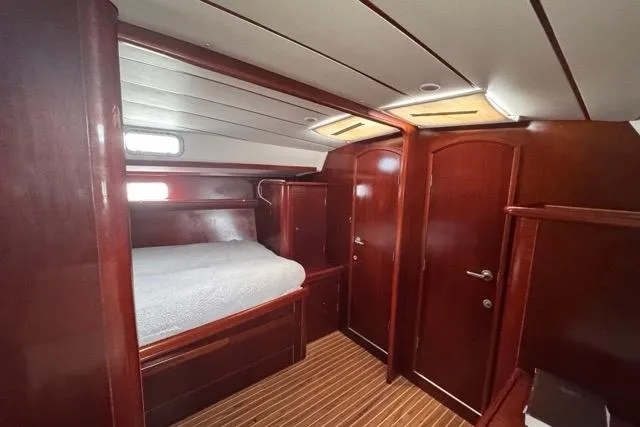 Must Love Dogs Yacht Photos Pics Luxurious cabin interior of 1996 Beneteau 50 yacht with wooden finish and cozy bed.