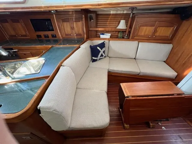 L'attitude Yacht Photos Pics Spacious interior of 1996 Sabre 402 yacht with cozy seating and wooden cabinetry.