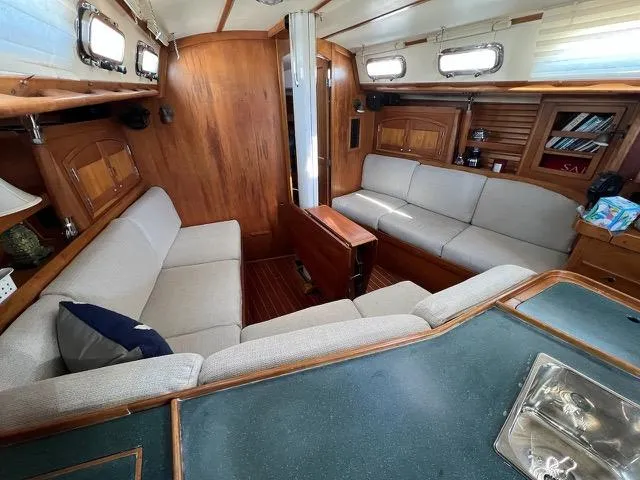 L'attitude Yacht Photos Pics Interior of 1996 Sabre 402 sailboat with cozy seating and wooden finishes.
