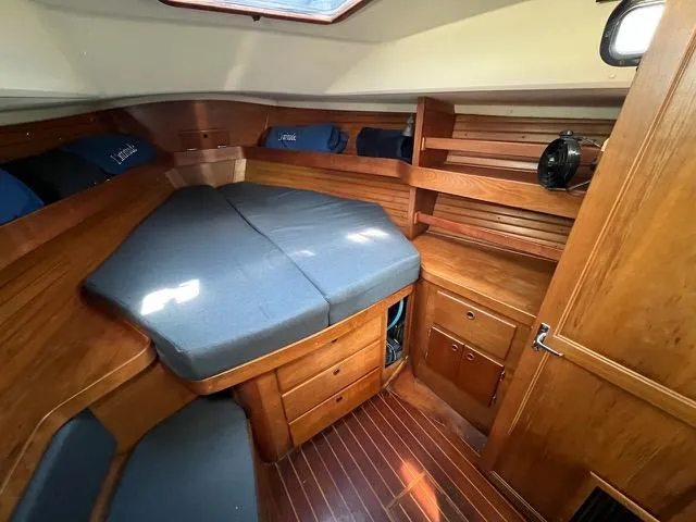 L'attitude Yacht Photos Pics Cozy cabin interior of a 1996 Sabre 402 sailboat with wooden furnishings and a comfortable bed.