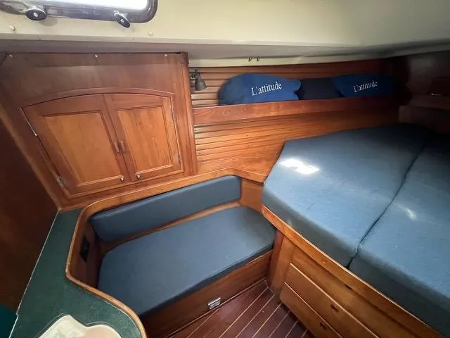 L'attitude Yacht Photos Pics Cozy cabin interior of 1996 Sabre 402 sailboat with wooden furnishings and blue cushions.