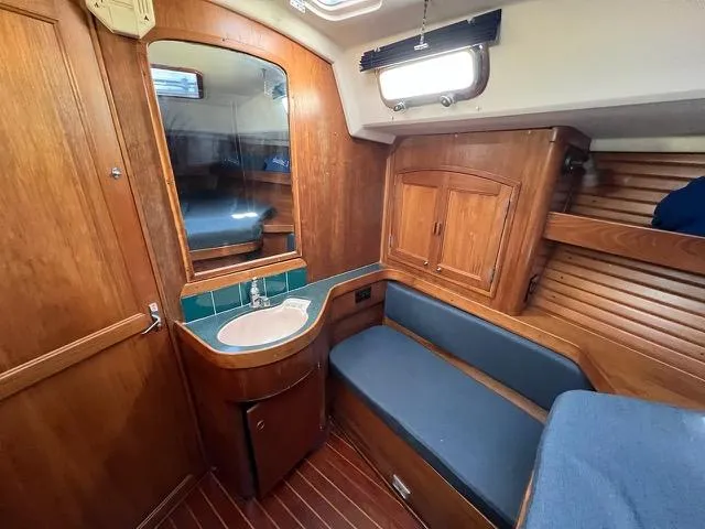 L'attitude Yacht Photos Pics Interior of 1996 Sabre 402 yacht with wooden cabinetry and blue seating.
