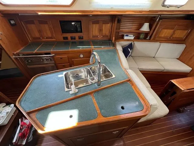 L'attitude Yacht Photos Pics Interior of a 1996 Sabre 402 yacht featuring a kitchen and seating area.
