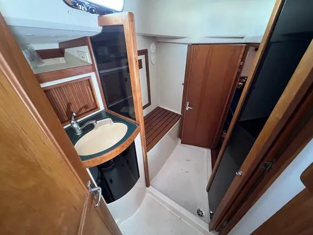 L'attitude Yacht Photos Pics Interior of 1996 Sabre 402 yacht bathroom with sink and wooden accents.