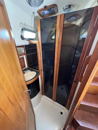 L'attitude Yacht Photos Pics 1996 Sabre 402 yacht interior with wooden cabinetry and compact bathroom.