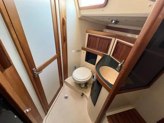 L'attitude Yacht Photos Pics Bathroom interior of 1996 Sabre 402 yacht with wooden accents and compact design.