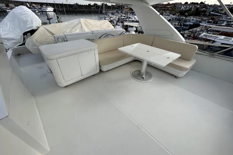  Yacht Photos Pics Flybridge seating area on a 2002 Sanlorenzo SL72 yacht, featuring a table and cushioned benches.