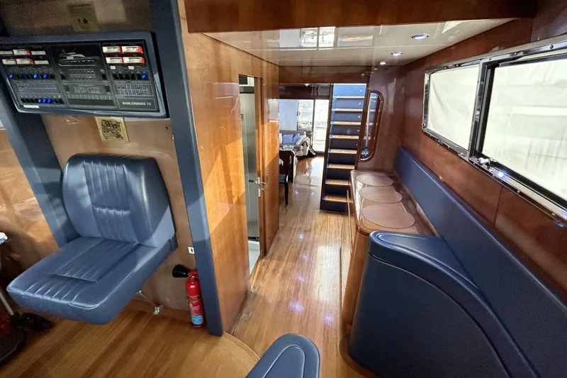  Yacht Photos Pics Interior of 2002 Sanlorenzo SL72 yacht with wood paneling and blue seating.