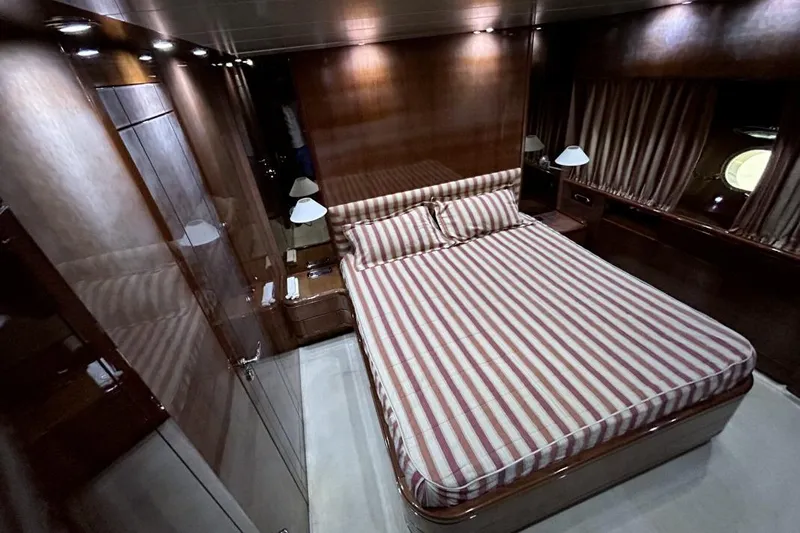  Yacht Photos Pics Luxurious bedroom interior of 2002 Sanlorenzo SL72 yacht with striped bedding.