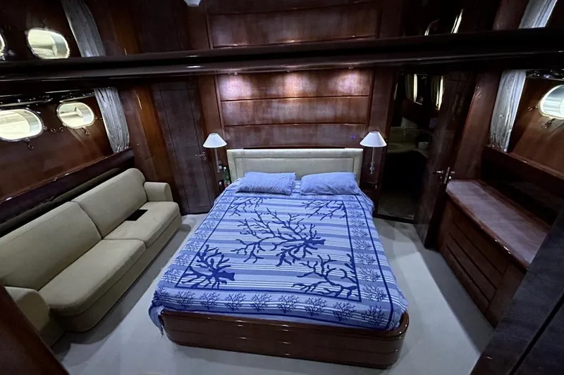  Yacht Photos Pics Luxurious Sanlorenzo SL72 2002 yacht bedroom with elegant wood paneling and cozy furnishings.