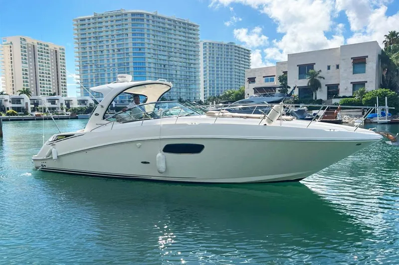 2012 Sea Ray 370 Da @ Cancun Sogu Yacht Photos Pics 2012 Sea Ray 370 Sundancer yacht on calm water, with modern buildings in the background.