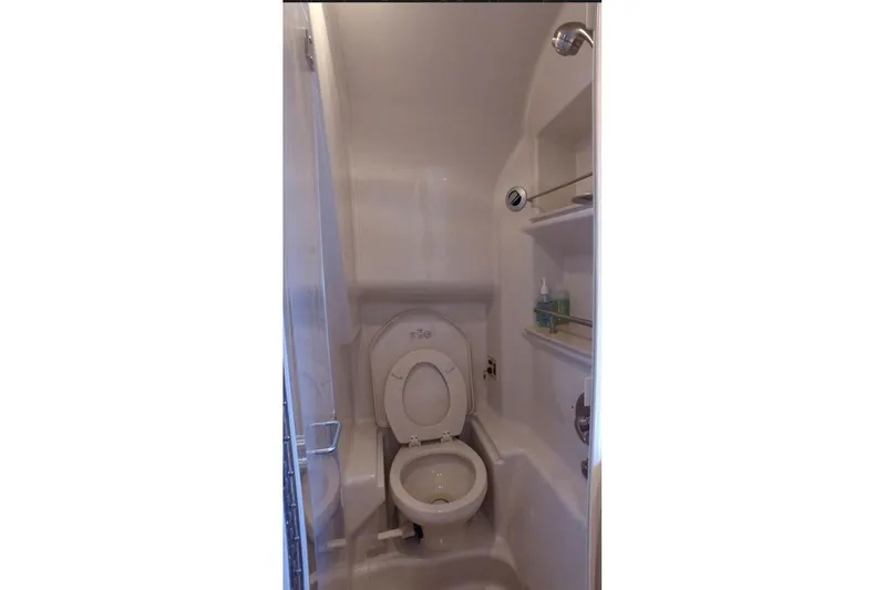 2012 Sea Ray 370 Da @ Cancun Sogu Yacht Photos Pics Bathroom interior of 2012 Sea Ray 370 Sundancer yacht with toilet and shelves.