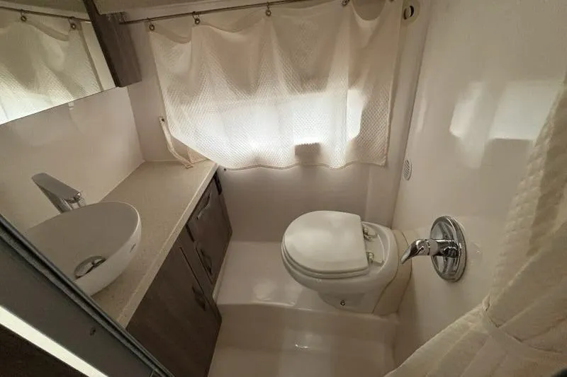  Yacht Photos Pics 2019 Regal 33 XO boat bathroom with sink, toilet, and curtain.