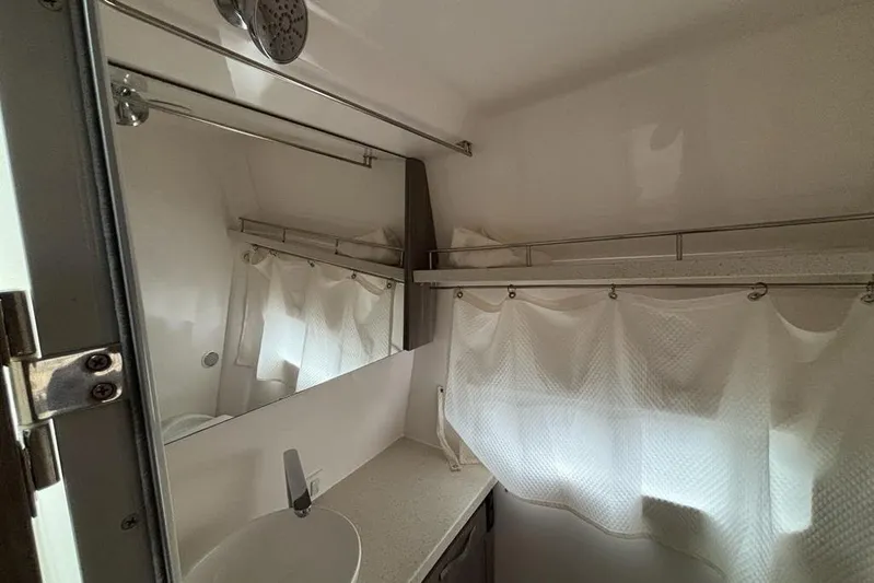  Yacht Photos Pics Bathroom interior of 2019 Regal 33 XO boat with sink, mirror, and curtain.