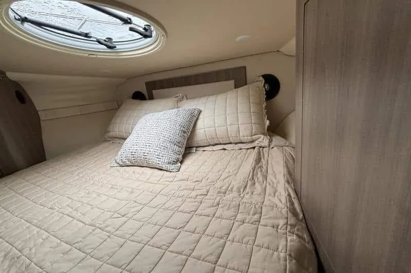  Yacht Photos Pics Cozy cabin interior of 2019 Regal 33 XO yacht with plush bedding and porthole.