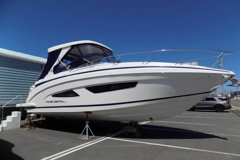  Yacht Photos Pics 2019 Regal 33 XO boat on display in a parking lot under clear blue sky.