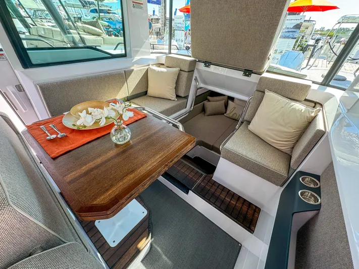  Yacht Photos Pics 2024 Axopar 37XC CROSS CABIN interior with cozy seating and elegant wooden table.