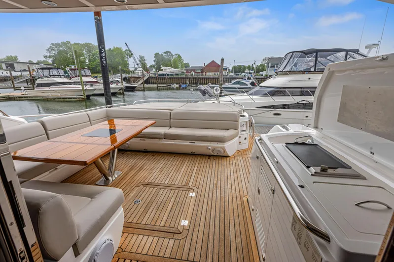 Diggin It Yacht Photos Pics Sunseeker Predator 68 (2015) yacht deck with seating, table, and marina view.