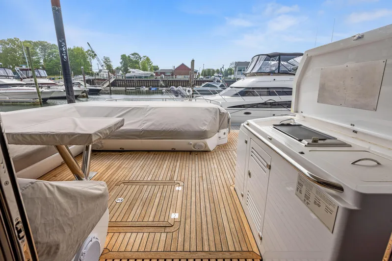 Diggin It Yacht Photos Pics Sunseeker Predator 68 (2015) yacht deck with covered seating and dock view.