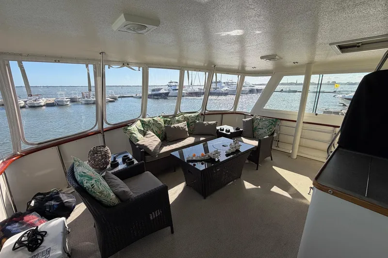 Lady Rae Yacht Photos Pics Interior of 1987 Hatteras 58 Motor Yacht with elegant seating and marina view.