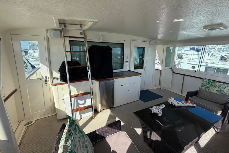 Lady Rae Yacht Photos Pics Interior of 1987 Hatteras 58 Motor Yacht with seating, table, and ladder.