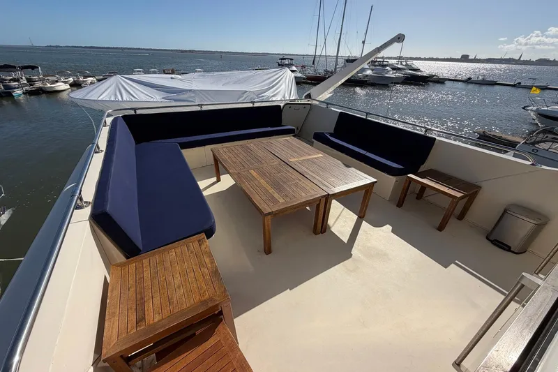 Lady Rae Yacht Photos Pics Spacious deck of 1987 Hatteras 58 Motor Yacht with wooden furniture and ocean view.