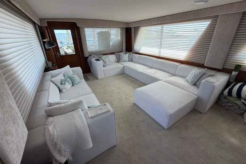 Lady Rae Yacht Photos Pics Luxurious interior of 1987 Hatteras 58 Motor Yacht with plush white seating and large windows.